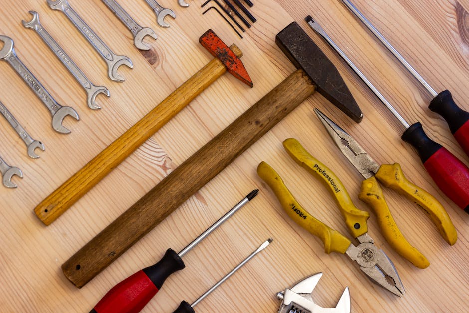 Tools like hammer screwdrivers are laid out on a light wooden table