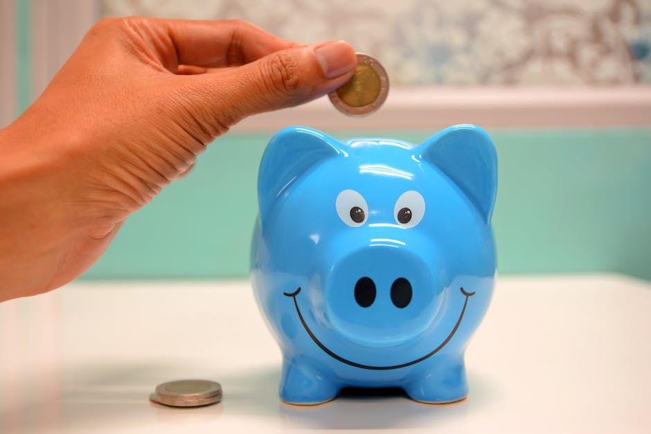 Person Putting Coin in a blue Piggy Bank